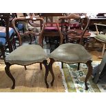 A pair of Victorian mahogany side chairs, the shaped top with carved top rail, with shaped