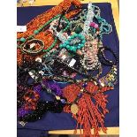 A mixed lot of necklaces including a multi strand bead necklace, a coral style choker, a polished