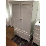 A Victorian style white painted wardrobe, the plain top with moulded edge above a pair of panelled