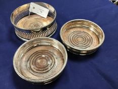 Three silver plated wine slides with mahogany bases (some wear to plate) (largest: 6cm x 15cm)