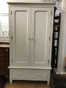 A Victorian style white painted wardrobe, the moulded top with carved frieze above twin panel doors,