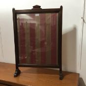 An early 20thc mahogany glazed firescreen with striped silk panel, on shaped supports (h.81cm x 55cm