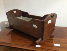 A 19thc. mahogany childs dolls crib on rockers, the curved ends with heart shaped panels, with plank