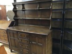 An Ercol two part oak dresser, the open top with two shelves, on shaped supports, with panel back,