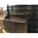 An Ercol two part oak dresser, the open top with two shelves, on shaped supports, with panel back,