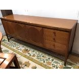 A vintage teak sideboard, the rectangular top with rounded angles, above three cupboard doors with