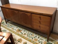 A vintage teak sideboard, the rectangular top with rounded angles, above three cupboard doors with