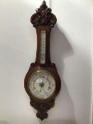 A late 19thc./early 20thc. carved oak banjo barometer, the carved top above a removable cased