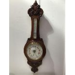 A late 19thc./early 20thc. carved oak banjo barometer, the carved top above a removable cased