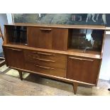 A G Plan style teak sideboard, the rectangular top above a central fall front, enclosing a mirror