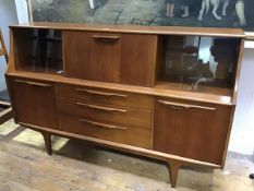 A G Plan style teak sideboard, the rectangular top above a central fall front, enclosing a mirror