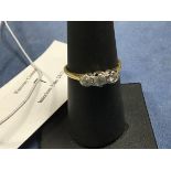 A three stone diamond ring on unmarked yellow metal band (O) (2.1g)