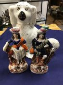 A 19thc Staffordshire chimney Spaniel and a pair of Highland Staffordshire figures decorated with