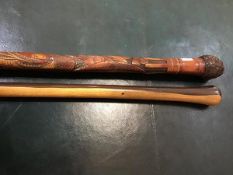 An early 20thc carved Japanese walking cane, with root knot pommel, with a carved entwined snake and