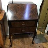 A 1930s/40s walnut bureau, the plain top with rounded angles, with fall front enclosing a fitted