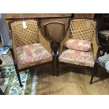 A pair of 1920s mahogany library style chairs, with sweeping arms, with canework back and sides