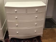 A Georgian style white painted bow front chest of drawers, the top with moulded edge above two short