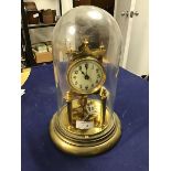 A brass eight hundred day clock, on three columns, on circular brass stand with revolving