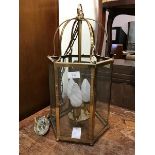 A 19thc. style brass hexagonal hall lantern, the top as a cage with six glazed panels, on ball feet,