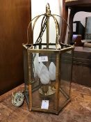 A 19thc. style brass hexagonal hall lantern, the top as a cage with six glazed panels, on ball feet,