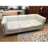 A Le Corbusier LC2 style three seater white leather effect and chrome sofa (70cm x 186cm x 80cm)