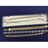 A group of white metal bracelets and chains, including a three strand rope fancy link bracelet (