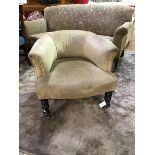 A Victorian upholstered low back horseshoe shaped tub chair, on turned supports with later castors