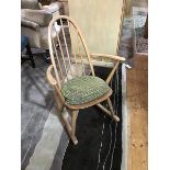 An Ercol beech spindle back rocking chair, blue label to rear of seat, with pop on pad cushion (h.