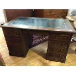 A 19thc/20thc. oak twin pedestal knee hole desk, the rectangular top with inset leather skiver,