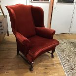 A George III style mahogany framed wing chair, late 19thc. with loose cushion seat, raised on