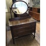 A 1920s oak dressing chest, the oval mirror on turned supports, the rectangular top with moulded