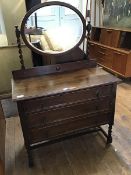 A 1920s oak dressing chest, the oval mirror on turned supports, the rectangular top with moulded