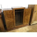 A 1930s/40s walnut stepped side cabinet, the centre section with rectangular top above an astragal