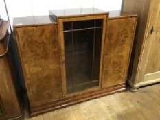 A 1930s/40s walnut stepped side cabinet, the centre section with rectangular top above an astragal