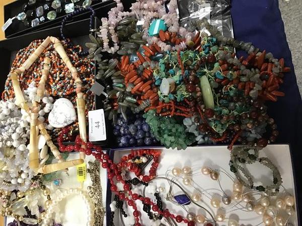 A mixed lot of beads and necklaces including a red hardstone necklace with yellow metal clasp marked
