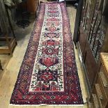 A Caucasian hand knotted wool runner, the central panel with alternating geometric medallions