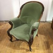 A mid-19th century walnut framed armchair, the arched back embellished with scrolls and foliage