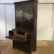 A late 19th century secretaire bookcase of George III design, the projecting dentil cornice above