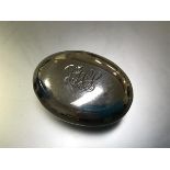 A George V silver tobacco box, Birmingham 1912, of flattened oval form, with sprung cover and