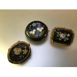 A group of three 19th century brooches, one oval, the floral pietra dura panel within a gilt metal