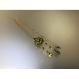 An Edwardian peridot and seed pearl pendant/brooch, of flowerhead form, set with six oval-cut