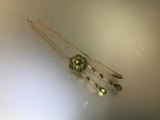 An Edwardian peridot and seed pearl pendant/brooch, of flowerhead form, set with six oval-cut