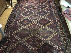 A Turkoman rug, the madder field all-over decorated with four cojoined ivory medallions,