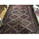 A Turkoman rug, the madder field all-over decorated with four cojoined ivory medallions,