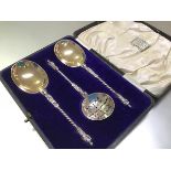 A cased set of three Edwardian silver fruit servers and sifting spoon, William Hutton & Sons Ltd,