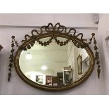 An Edwardian giltwood wall mirror c.1900, the oval plate within a moulded frame embellished with