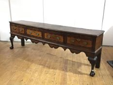 A George II elm low dresser, the rectangular top with moulded edge, above four crossbanded frieze