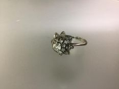 A diamond flowerhead cluster ring, the central round brilliant-cut stone weighing approximately 0.33