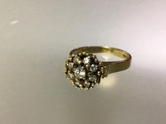 A diamond cluster ring, the domed arrangement of round brilliant-cut diamonds on an 18ct yellow gold