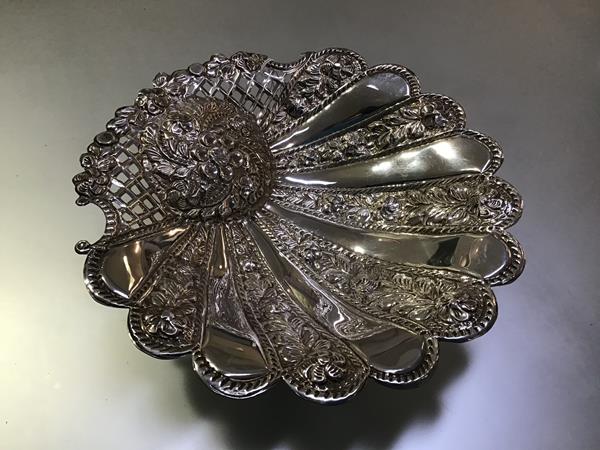 A Cairo white metal bon-bon dish, of stylised shell-form, with alternating plain and floral sections